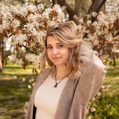 1. Porträt einer Frau vor blühendem Kirschbaum, Frühlingsgefühle, Natur, natürliche Schönheit.