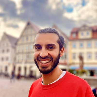 Begeisterter Mann vor historischen Gebäuden in einer europäischen Stadt, Urban Life, Freizeit, Kultur, Stadtbild, Lifestyle.