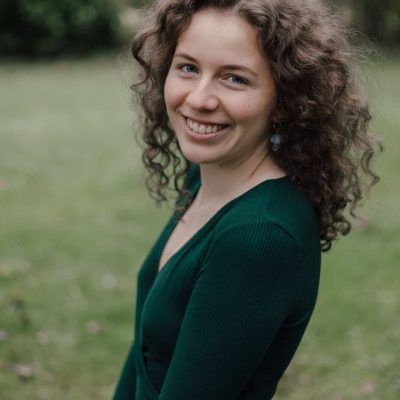 Freundliche Frau im grünen Kleid, Naturhintergrund, professionelles Porträt, persönliche Entwicklung, Selbstvertrauen, Sommer, Lifestyle.